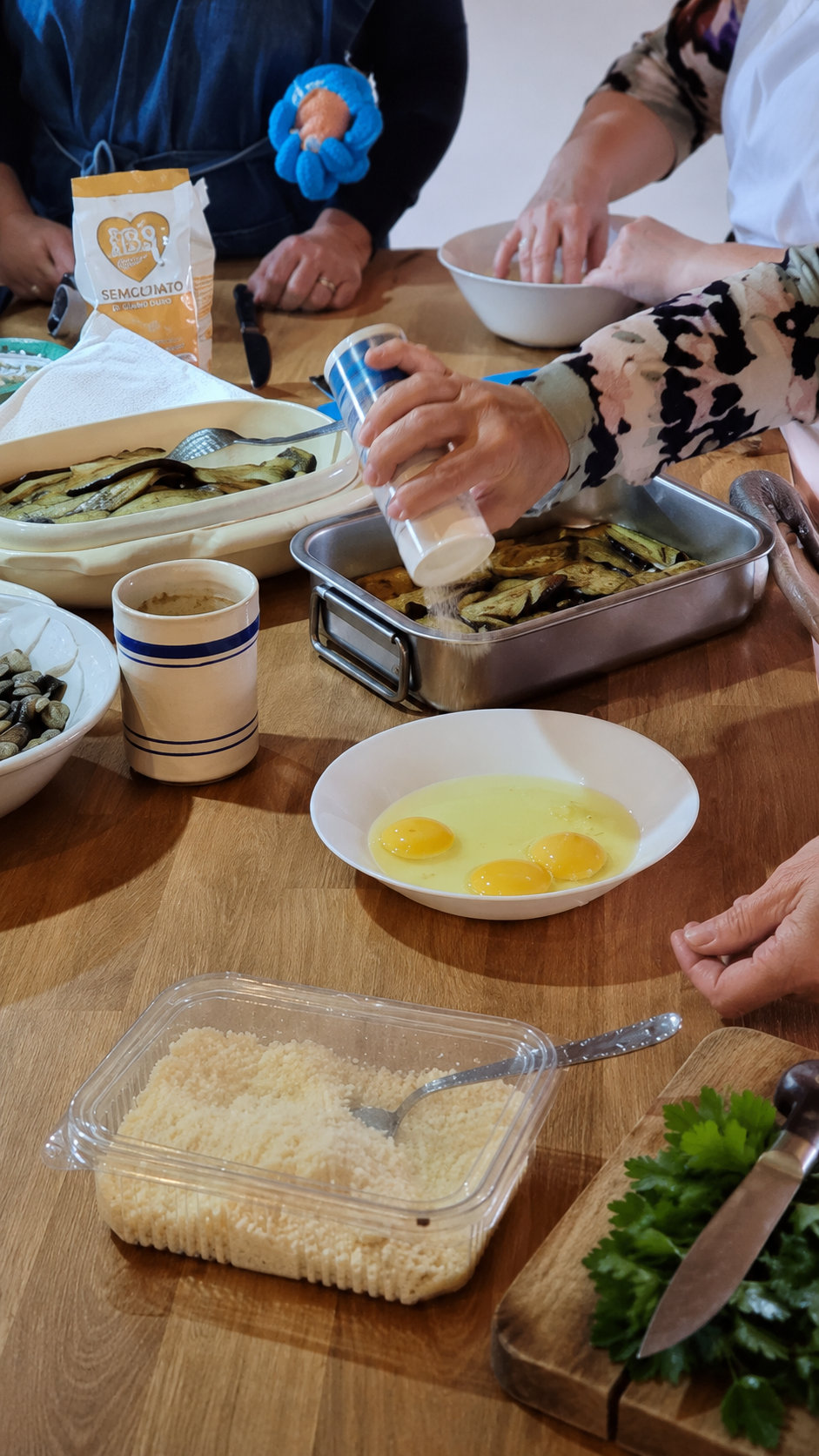 Hands preparing fresh Sicilian pasta with local ingredients on a rustic kitchen table